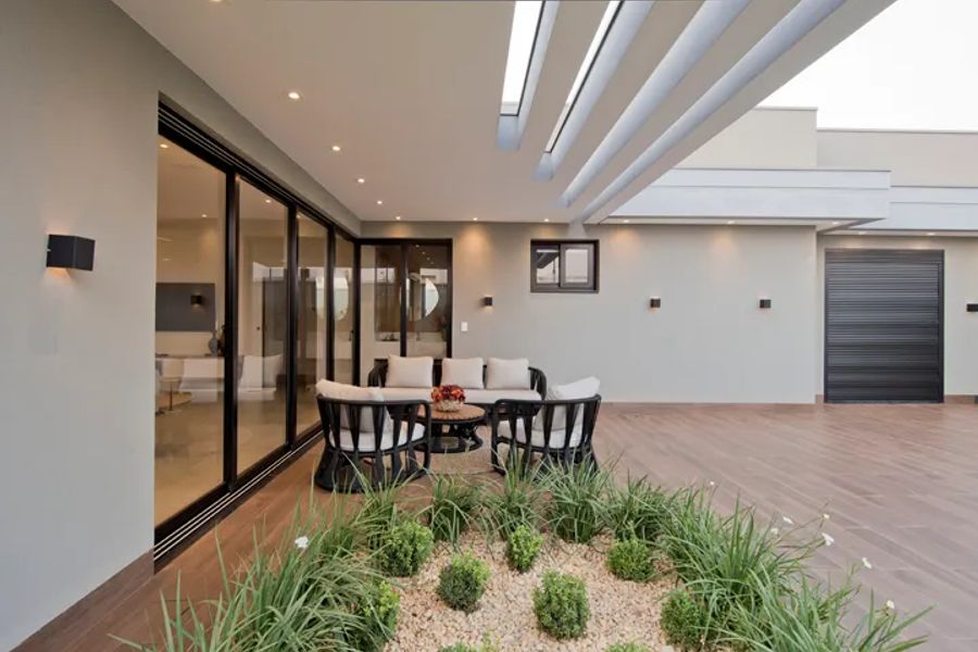 Escritório de arquitetura em Rio Brilhante MS: ambiente social com jardim interno de projeto residencial de alto padrão por Juliana Saraiva